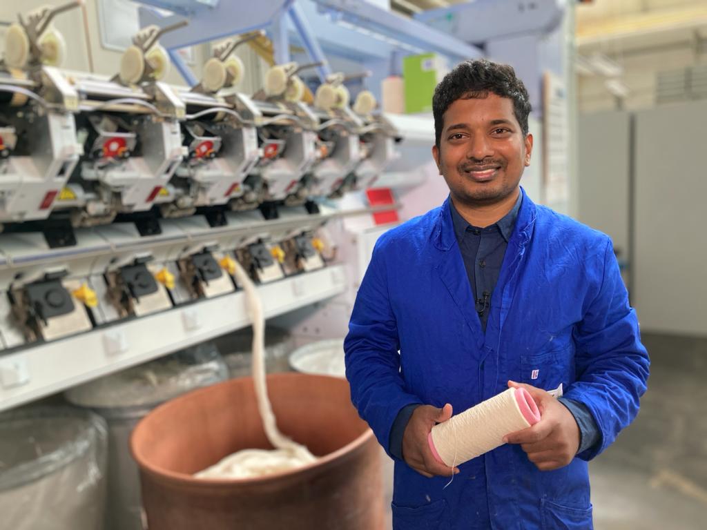 Rony Khan, founder of Re-Root-Tex, holding pineapple leaf fibre yarn on the factory floor
